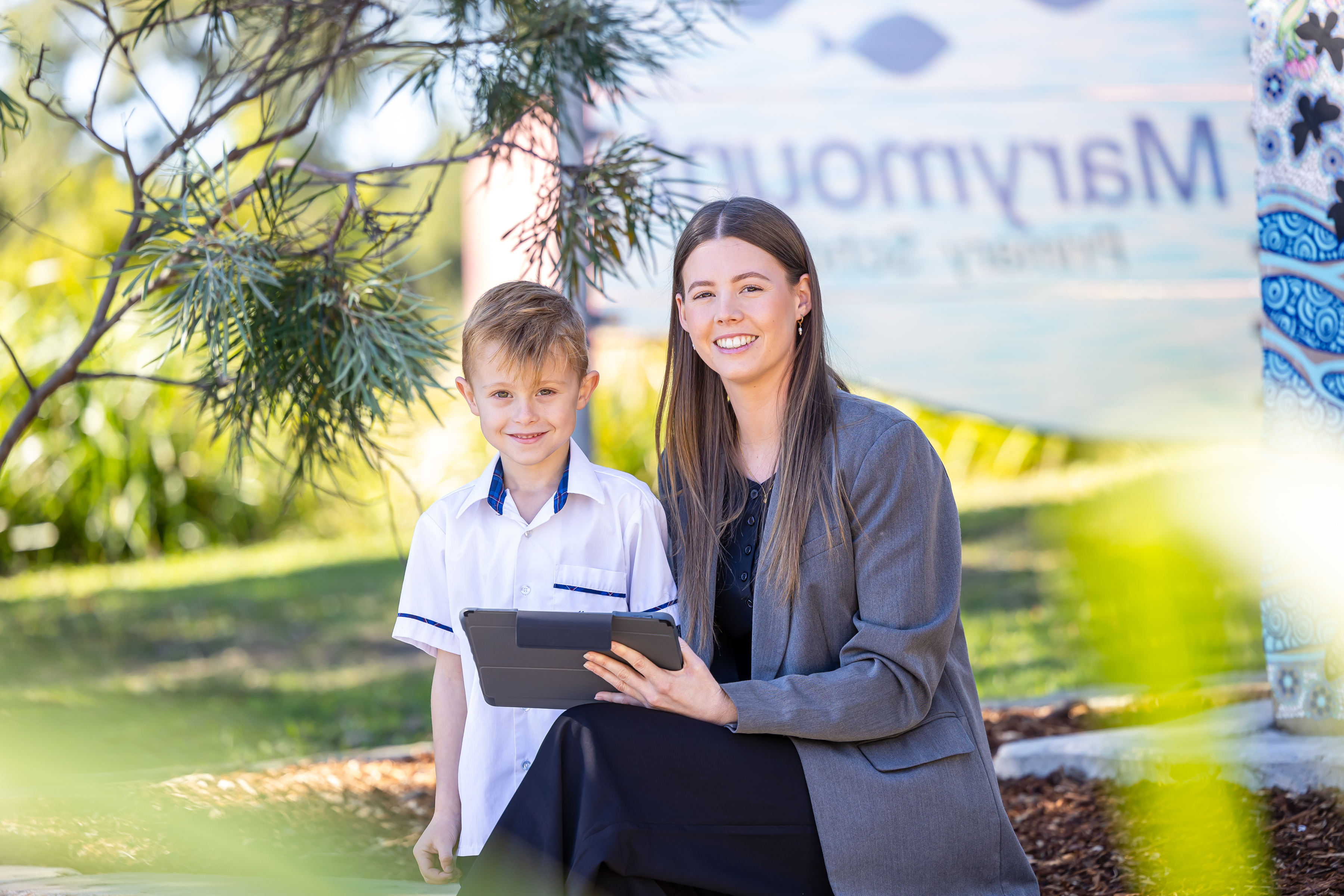 Teacher and student outside with an iPad.
